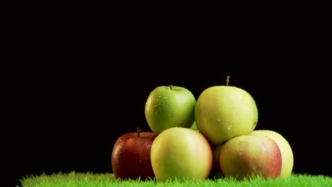 Haufen-Glänzender,-Lebendiger-Äpfel-Auf-Grüner,-Rotierender-Oberfläche