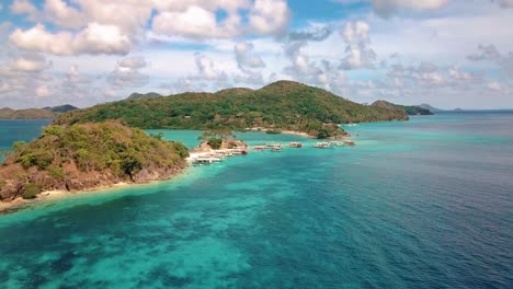 Luftaufnahme-Der-Insel-Bulog-In-Coron,-Palawan,-Philippinen-Mit-Schwimmenden-Touristen-Und-Am-Strand-Geparkten-Booten