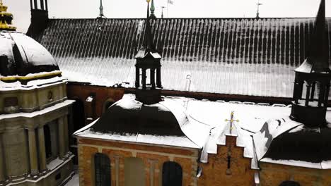 Zoom-out-aerial-view-of-tapered-conical-structures-on-rooftop-of-old-church-in-Stockholm,Sweden