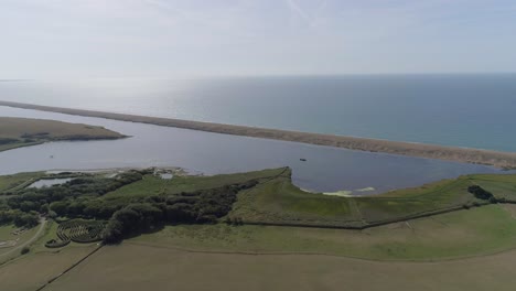 Aerial-tracking-forward-from-inland-towards-the-fleet-lagoon-at-Abbotsbury-in-Dorset