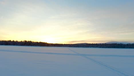 Luftaufnahme-Einer-Winterlandschaft-Mit-Wäldern-Und-Bergen-Bei-Sonnenuntergang-In-Gällivare,-Im-Norden-Schwedens