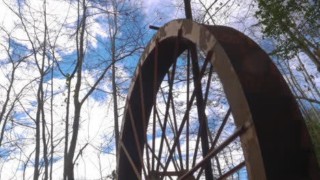 An-old-rusted-waterwheel-turning-against-the-sky-on-a-forest-at-Georgia