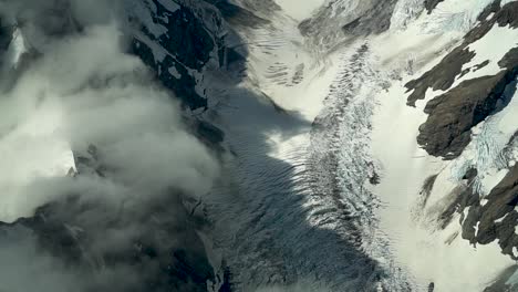 Hooker-glacier,-Southern-Alps,-New-Zealand-with-clouds,-snow-and-rocky-mountains-from-scenic-airplane-flight