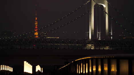 Tilting-shot-revealing-Tokyo-Tower-and-Rainbow-Bridge-in-Odaiba-at-night