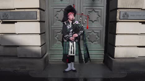 Static-of-of-a-musician,-bagpiper-wearing-a-Scottish-kilt-and-performing-on-the-streets-of-Edinburgh,-Scotland-in-the-old-town-playing-the-bagpipes-on-a-sunny-day