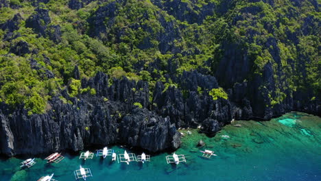 Luftaufnahme-Einer-Versteckten-Lagune-Mit-Vielen-Geparkten-Spinnenbooten,-Coron,-Palawan,-Philippinen