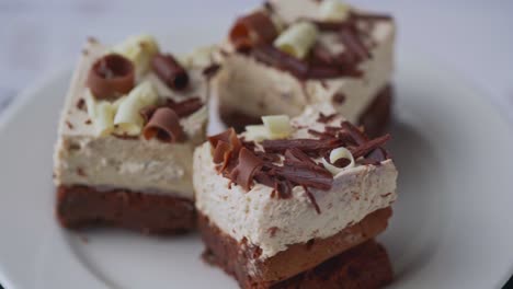 Three-chocolate-cream-desserts-on-a-white-plate,-rotation