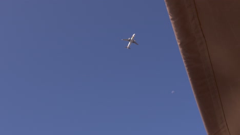 Airplane-flying-over-the-Lisbon-Bride-with-the-moon-on-the-frame