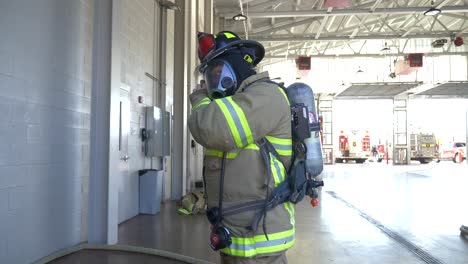 Firefighter-puts-on-firefighting-gear-with-air-tank-and-helmet-to-be-ready-to-fight-a-fire