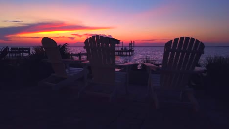 Eine-Friedliche-Aufnahme-Einer-Sitzecke-Mit-Blick-Auf-Das-Wasser-Während-Eines-Spektakulären-Sonnenuntergangs