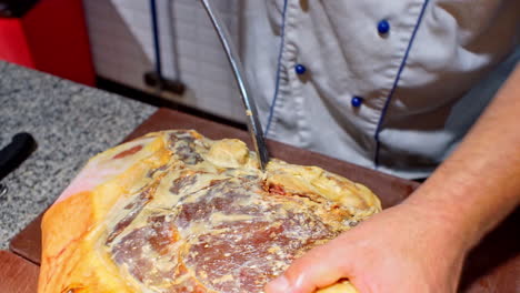 Close-up-footage-of-cook-preparing-a-prosciutto