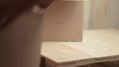 Arbeiter-Bewegt-Und-Stapelt-Kartons-Auf-Einer-Holzpalette