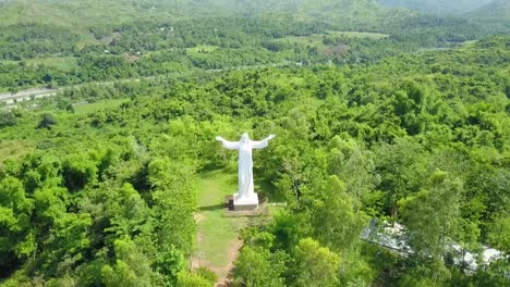 Toma-De-Drones-De-La-Montaña-Peregrina-Del-Monte-Sión-Con-Una-Gigantesca-Escultura-De-Jesucristo-Detrás-De-Una-Montaña-Escénica