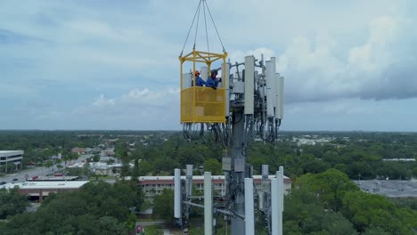 4K-Aerial-video-of-telecommunications-tower-being-serviced-by-technicians