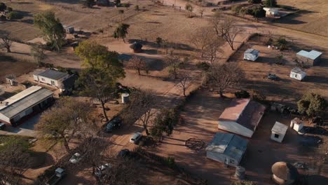 Eine-Nach-Links-Gedrehte-Drohnenaufnahme-Einer-Afrikanischen-Ländlichen-Wohnanlage-Unter-Sonnigen-Bedingungen