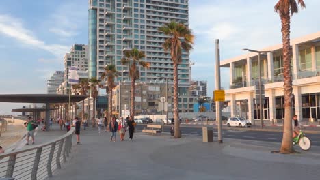 Menschen-Radeln,-Laufen-Und-Gehen-Auf-Einer-Straße-In-Strandnähe-In-Tel-Aviv,-Israel
