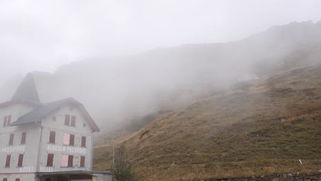 Wolken-Klettern-Den-Hang-Eines-Hügels-In-Der-Felsigen-Berglandschaft-Hinter-Dem-Hotel-Hinauf---Klausenpass,-Schweiz