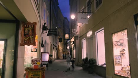 Salzburg,-Austria-–-October-11,-2019:-Shopping-street-at-night-with-people-in-Salzburg