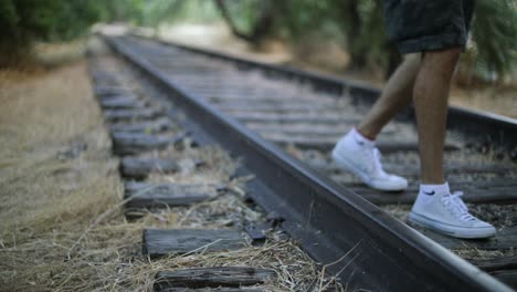 Slow-Motion-Shot-of-someone-walking-on-abandoned-Train-Tracks-towards-the-camera