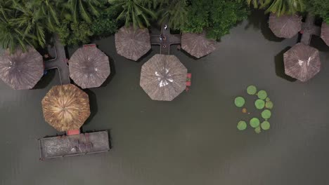 aerial-view-of-a-group-of-traditional-asian-hexagonal-shaped-buildings-built-over-a-lake-joined-to-each-other-and-the-shore-by-elevated-walkways
