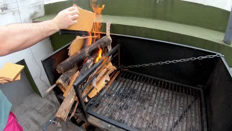video-of-a-white-man-lighting-the-fire-with-paperboard-to-grill-on-a-sunny-day