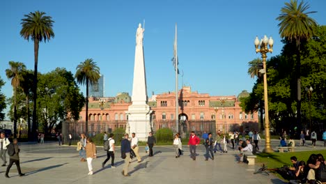 People-walking-and-May-Pyramid-and-Pink-House-in-May-Square,-Buenos-Aires,-Argentina