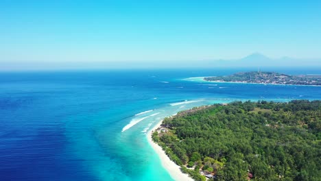 Paradise-seascape-of-tropical-islands-in-Bali-surrounded-by-blue-turquoise-sea-stream-waving-over-white-beaches-on-a-misty-morning-sky
