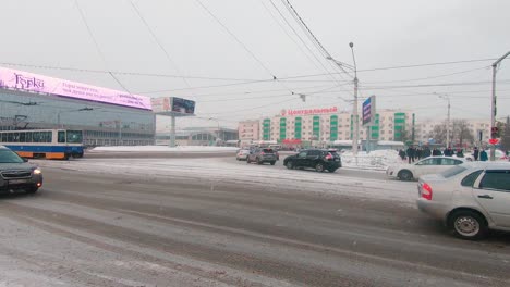 Cars-and-tram-driving-along-Revolutionary-street-capped-in-snow-in-Ufa,-Russia