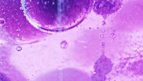 Makroaufnahme-Großer-Und-Kleiner-Violetter-Blasen,-Die-In-Leuchtend-Violettem-Wasser-Schwimmen-Und-Tropfen
