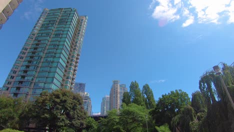 Low-angle-view-of-tall-skyscrapers-and-tree-tops-near-city-center-of-Vancouver-BC-Canada