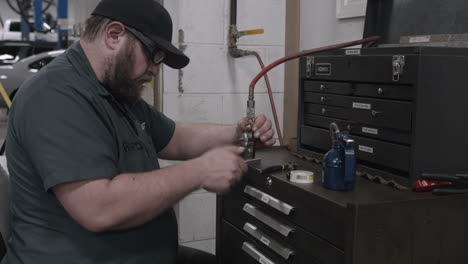 Ein-Automechaniker-Repariert-Ein-Gasdruckventil-In-Einer-Autowerkstatt