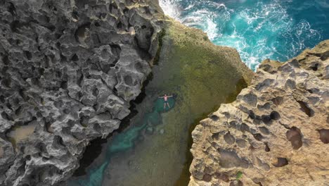 Luftaufnahme-Eines-Mannes,-Der-Im-Natürlichen-Billabong-Pool-Von-Angel-Schwimmt,-Boom-Up,-Bali