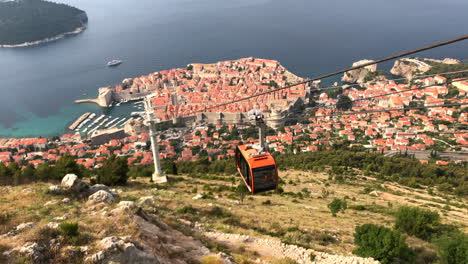 Hilltop-view-of-Dubrovnik-Old-Town-in-Croatia,-on-the-coast-of-the-Adriatic-Sea,-with-cable-car-descending-from-the-top-of-Srd-Hill