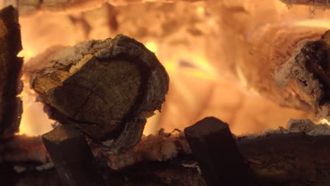 Wooden-logs-burning-and-glowing-in-fireplace,-close-up-time-lapse