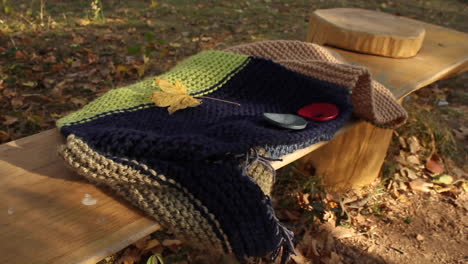 Quilted-blanket-resting-on-bench-outside-in-garden-during-autumn