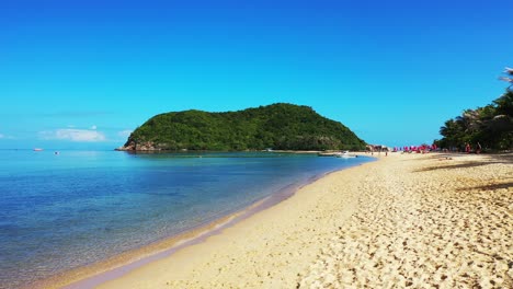 Vivid-colors-of-exotic-beach-with-white-sand-washed-by-calm-clear-water-of-blue-sea-and-green-hill-of-tropical-island-in-Thailand