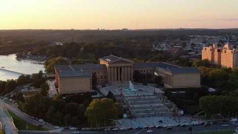 Rising-aerial-trucking-shot-at-Philly-Museum-of-Art-at-sunset,-golden-glow