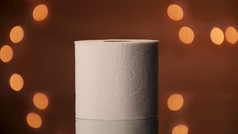 A-roll-of-toilet-paper-being-set-in-frame-with-a-beautiful-bokeh-backdrop