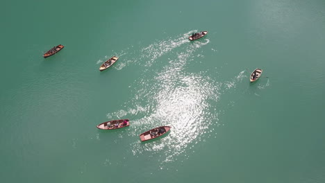 Group-of-Paddle-boaters-rowing-at-Lake-Braies-aka-Pragser-Wildsee,-Aerial-top-view-lift-shot