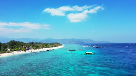 Paradise-vacation-destination-with-blue-turquoise-lagoon-washing-white-sandy-beach-on-green-tropical-island-under-bright-sky-with-clouds,-Bali