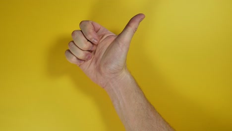 Männliche-Hand-Macht-Einen-Positiven-Daumen-Nach-Oben-Auf-Gelbem-Bildschirmhintergrund