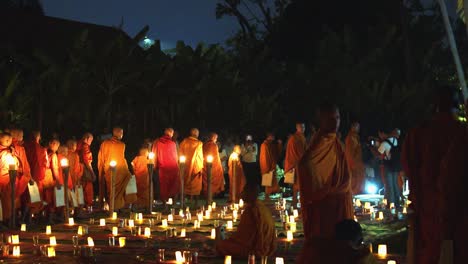 Mittlere-Außenaufnahme-Von-Vielen-Mönchen,-Die-In-Einer-Reihe-Mit-Vielen-Kerzenlichtern-Gehen