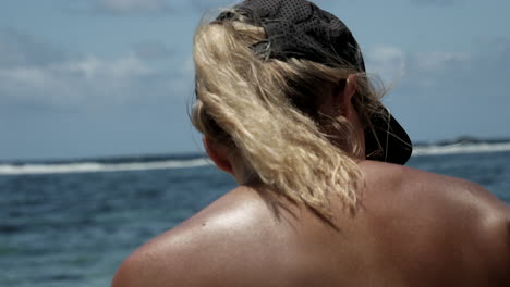 Close-up-rear-shot-of-head-of-beautiful-blonde-woman-on-beach-during-sunny-day