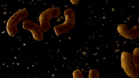 Peanut-flips-falling-down-in-slow-motion-with-black-background-surface