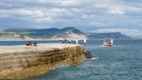 A-fishing-boat-returns-to-port-on-a-sunny-day-agaisnt-the-backdrop-of-the-jurassic-coast