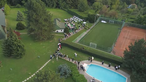 Top-view-of-a-wedding-party-in-a-club-with-tennis-court-and-swimming-pool