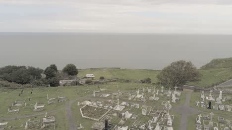 Tudnos-church-historic-mountain-chapel-aerial-view-overlooking-coastal-summit-graveyard-pull-back-over-roof
