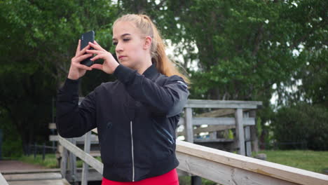 Mädchen-In-Sportkleidung-Geht-Im-Park-Spazieren-Und-Fotografiert-Mit-Ihrem-Smartphone