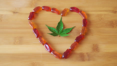 Slow-Motion-Hand-Picking-up-CBD-Gummy-from-Gummy-Heart-with-Marijuana-Leaf-in-Center