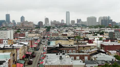 Aerial-truck-shot-of-Italian-Market-and-storefront-canopies-in-South-Philadelphia-neighborhood,-city-skyline-in-distance
